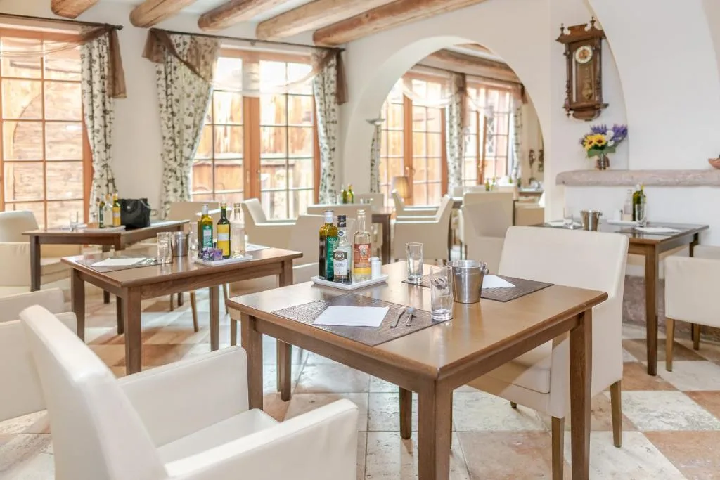 Sala ristorante luminosa con travi in legno e grandi finestre