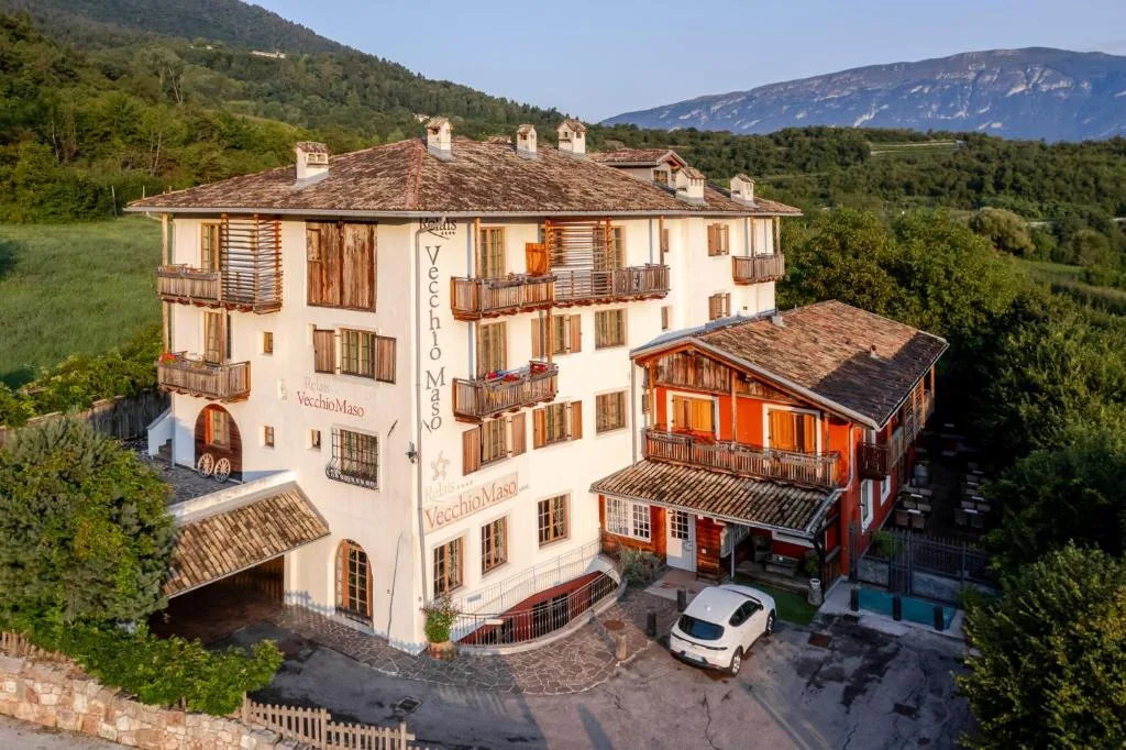 Vista aerea dell'hotel immerso nel verde con montagne sullo sfondo