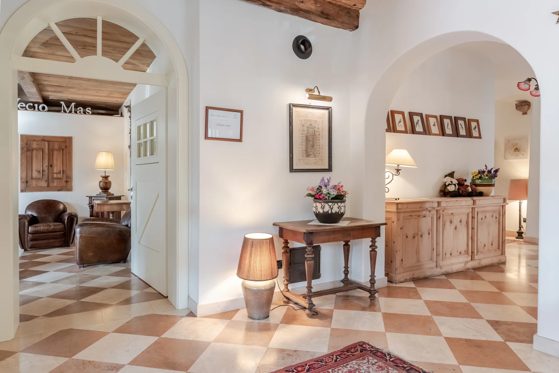 Ingresso interno con archi bianchi e pavimento a scacchi beige