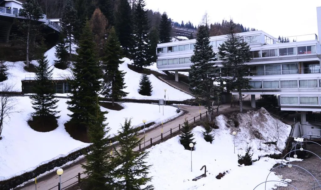 Vialetto tra gli edifici dell'hotel con neve e abeti in inverno