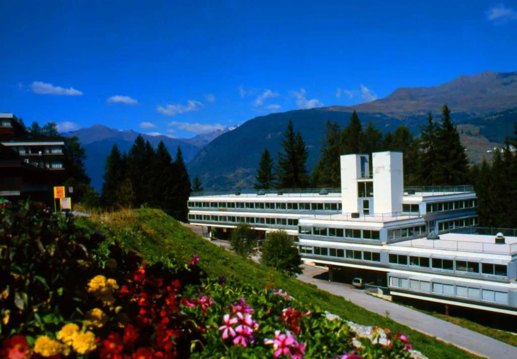 Veduta estiva dell'hotel con fiori colorati e panorama montano