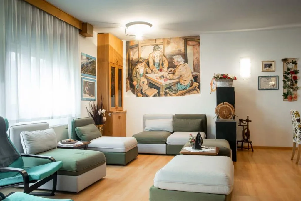 Zona relax con divani e poltrone e grande dipinto murale tradizionale