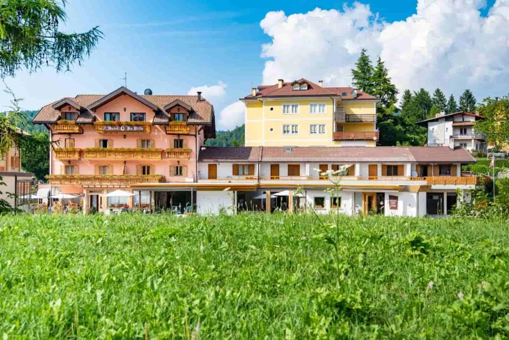 Vista dell'hotel dal prato verde con edifici e cielo azzurro