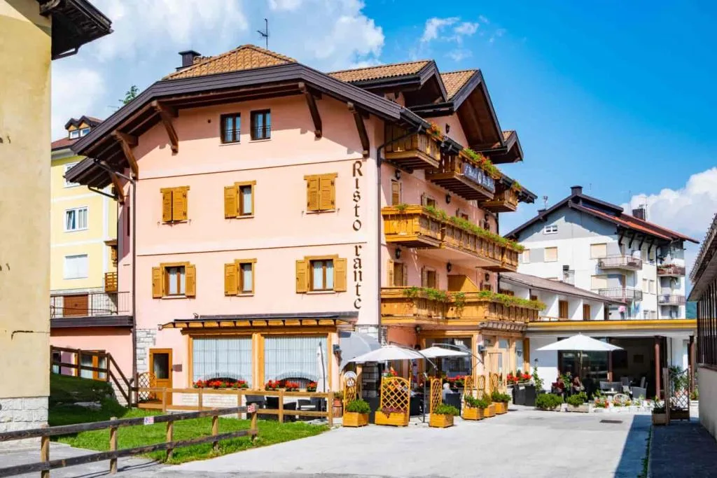 Facciata laterale dell'hotel con scritta Ristorante e dehor con ombrelloni