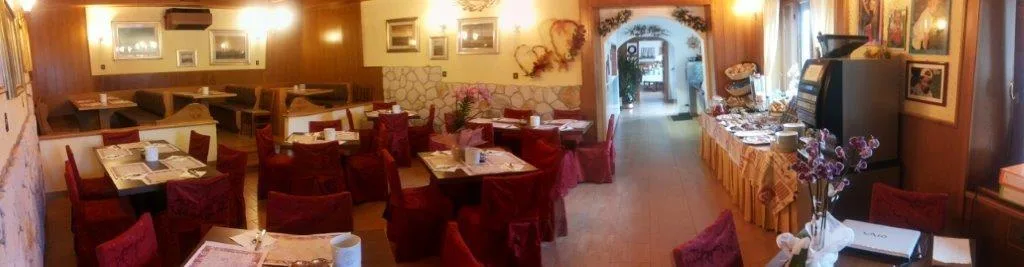 Sala colazione panoramica con sedie rivestite di rosso, buffet e decorazioni